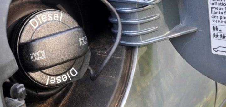 Close up of a solid black diesel fuel cap for an unidentified vehicle with the word "Diesel" in a sharp white font.
