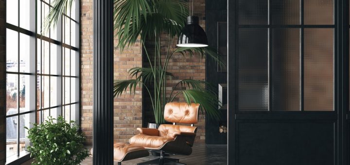 A living room loft featuring brick walls, a mid-century modern armchair, and industrial-style black finishes.