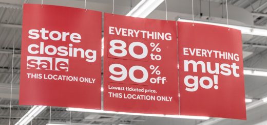 Red marketing banners inside a business hanging from the ceiling. The banners have white lettering for a sale.