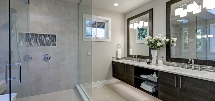A bathroom with a large walk-in shower, beige floor tiles, two sinks, large mirrors, ample light, and white walls.