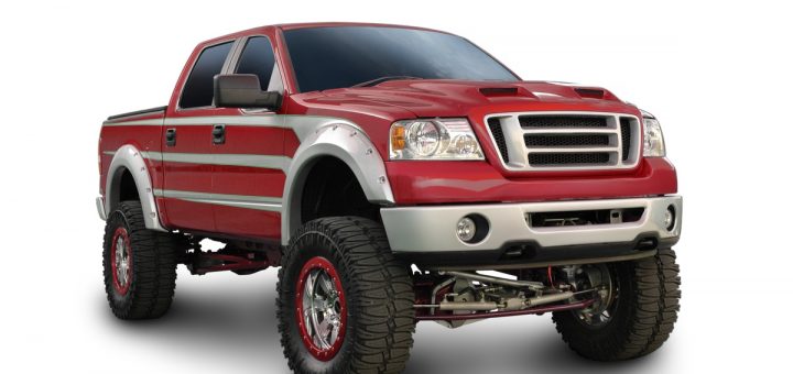 A red truck with silver trim is parked against a solid white background. The truck is clearly lifted with a greater height.