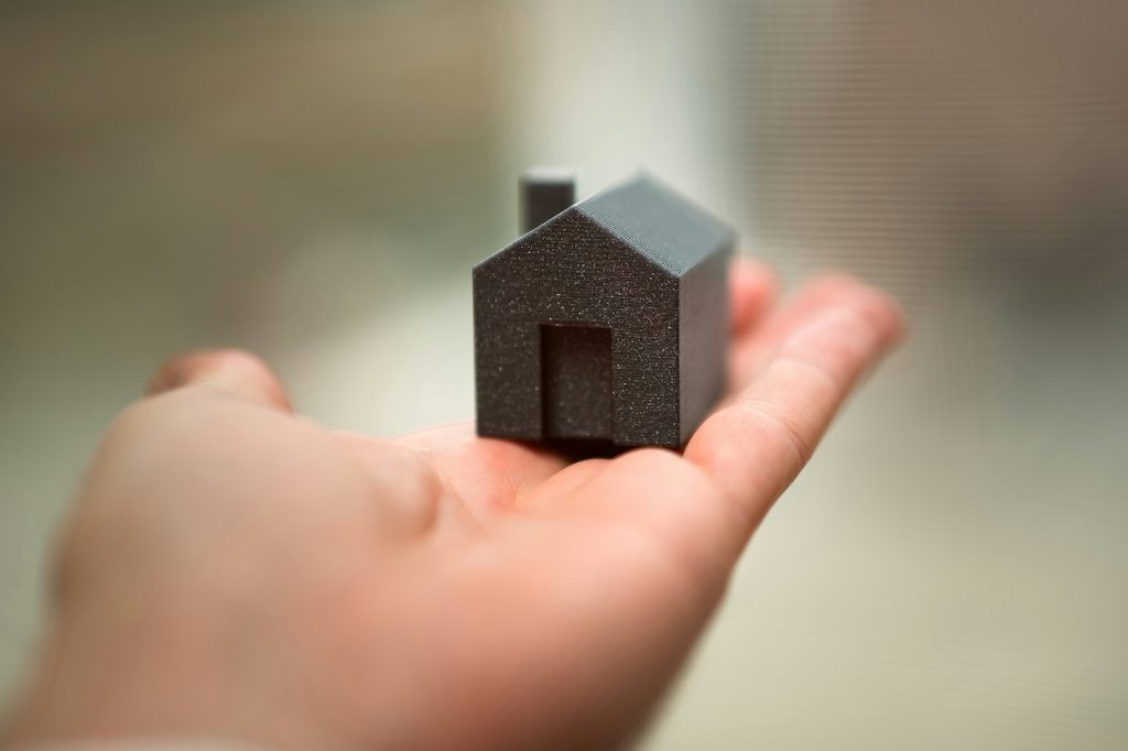 Small model house representing the benefits of downsizing