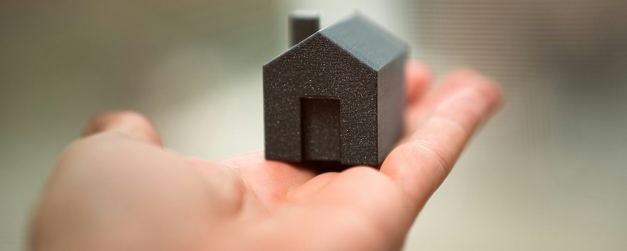 Small model house representing the benefits of downsizing