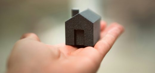 Small model house representing the benefits of downsizing