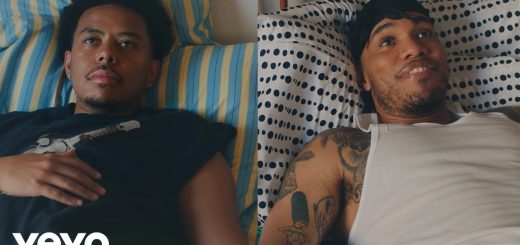 "Cordae and Anderson .Paak lying in bed in split-screen still from 'A Good Day' music video"