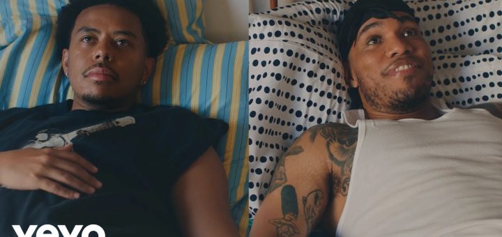 "Cordae and Anderson .Paak lying in bed in split-screen still from 'A Good Day' music video"