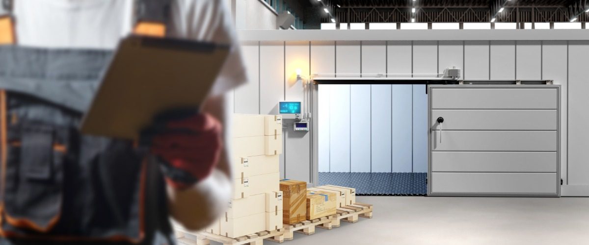 A person is holding a clipbord while they are standing in an industrial warehouse environment.