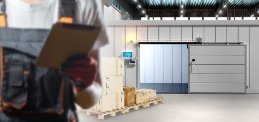 A person is holding a clipbord while they are standing in an industrial warehouse environment.