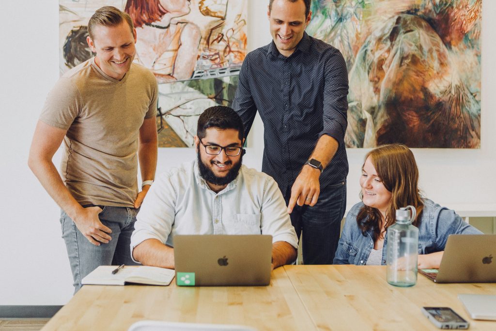 Creative professionals gathered around a computer coming up with ideas