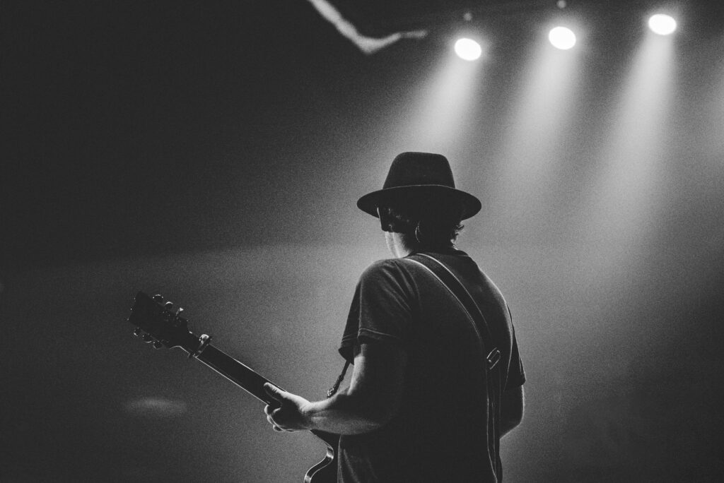 Independent music artist playing guitar on stage