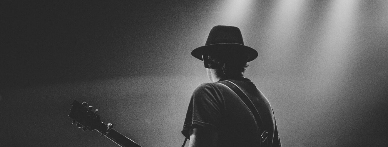 Independent music artist playing guitar on stage