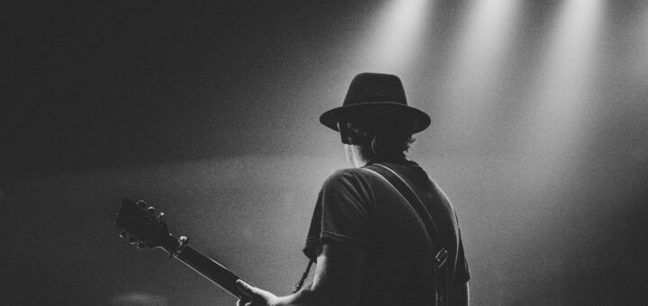 Independent music artist playing guitar on stage